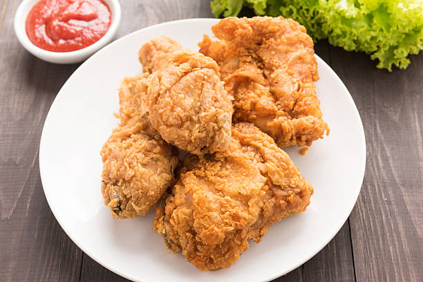 istock fried chicken drumstick and vegetables on wooden table 513307928