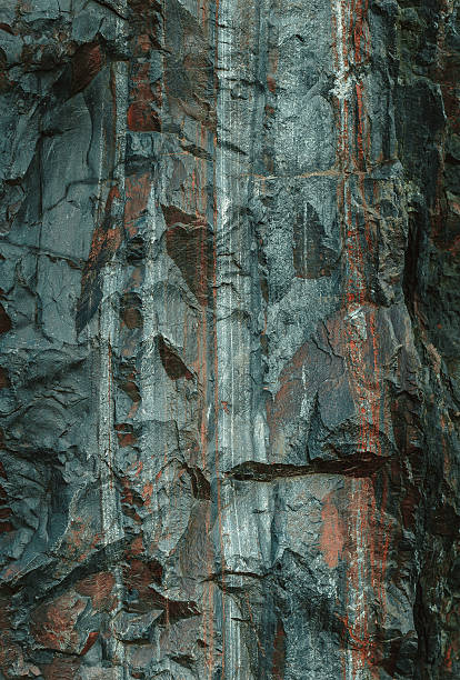 Slope of the granite cliff A monolithic granite boulder with veins of iron ore. Natural texture stone, volcanic rock. Mining in the quarry feldspar stock pictures, royalty-free photos & images