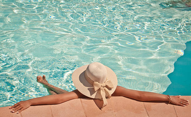 istock Woman in a pool hat relaxing in a blue pool 513314615