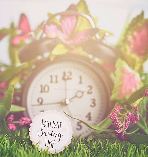 istock Clock in grass with spring foliage. Daylight Savings Time reminder 513315002