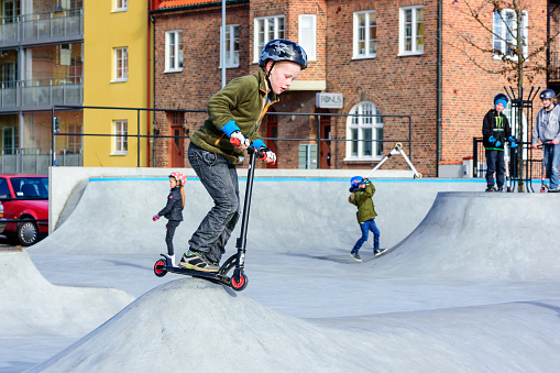 Solvesborg, Sweden - February 27, 2016: Children playing and having fun with scooters at the skatepark in central Solvesborg. Real people in everyday life.