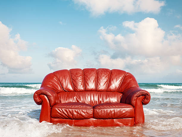 red vintage sofa in the sea stock photo