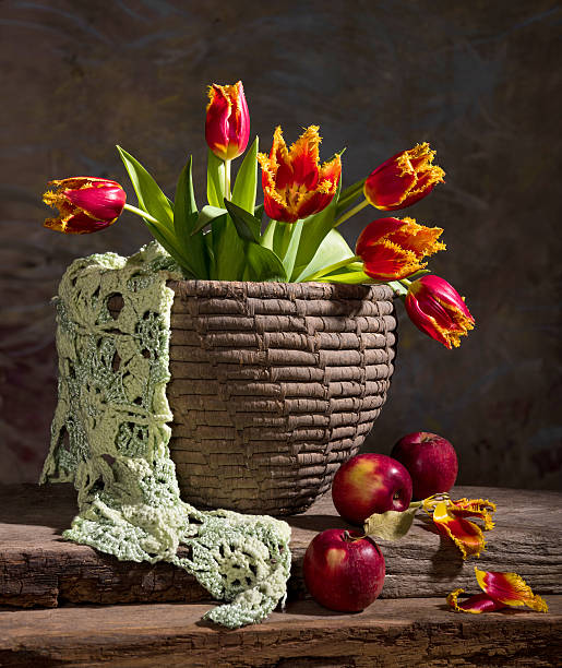 composition with pink terry tulips located in a white mug on a wooden table