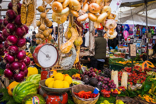 Rome, Italy - February 27, 2016: Rome, Italy - 27 February 2016:  View of people selling produce from a colourful market stall selling fruit and vegetables in the Campo de Fiori in Rome, Italy.  Image of contemporary lifestyle and daily life in Rome