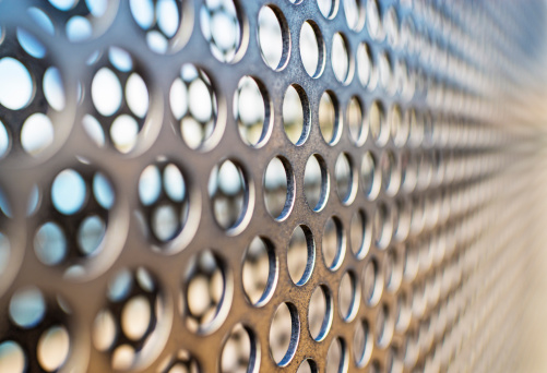 Metal fence patterned with round holes.