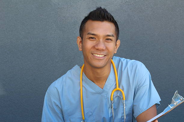 infermiere uomo asiatico sorridente con spazio copia sulla sinistra - originario delle isole delloceano pacifico foto e immagini stock