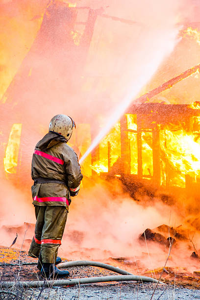 fireman extinguishes incendio - natural disaster fire office fire department fotografías e imágenes de stock