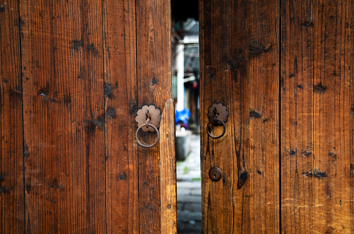 Door Knocker. Brown wooden door with metal knocker