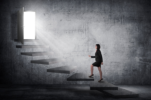 Asian business person going up to the door using stair. Business career conceptual