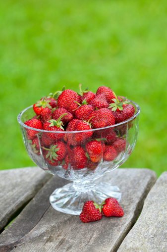 strawberries in a beautiful glass dish on wooden table