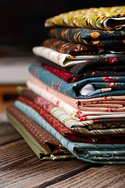 istock heap of cloth fabrics on wooden table 513357653
