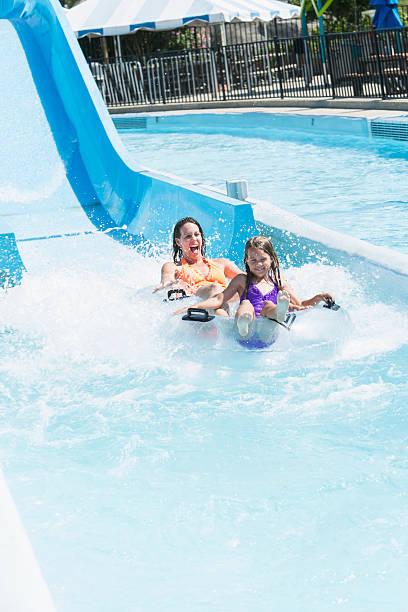 istock Mother and daughter on water slide 513358429