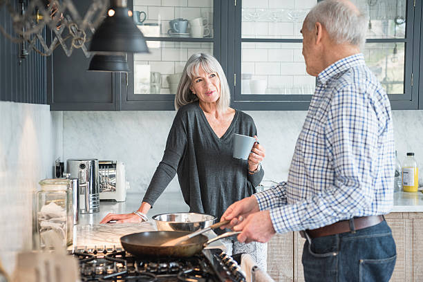 Senior couple in a kitchen making dinner and talking