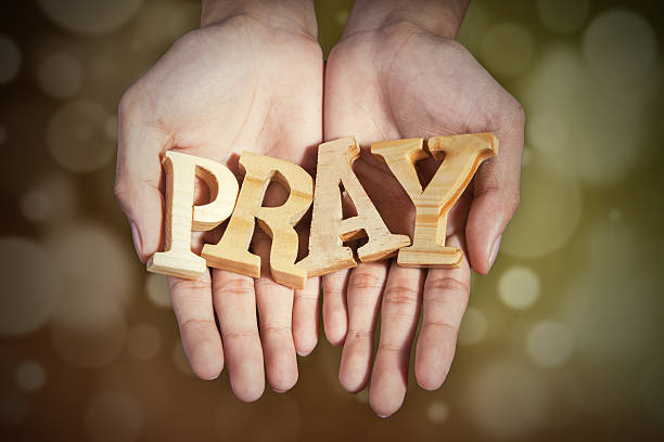 istock Hands with a word of pray in bokeh background 513364086