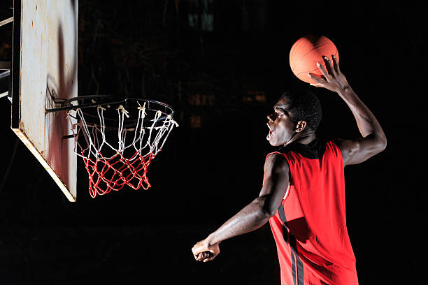 istock Man throwing basketball to makes slam dunk 513366410