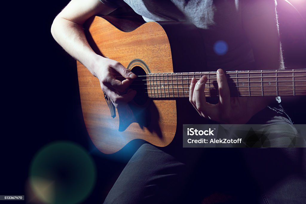 Musician playing on acoustic guitar Musician playing on acoustic guitar on dark background Guitar Stock Photo
