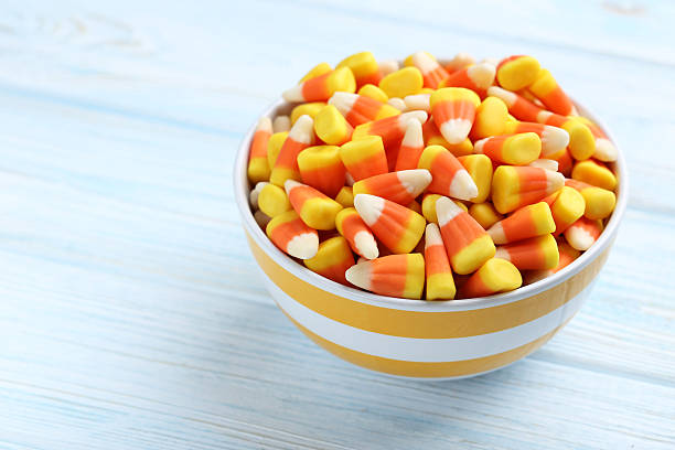 istock Halloween candy corns in bowl on blue wooden background 513368132