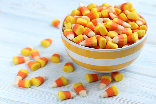 istock Halloween candy corns in bowl on blue wooden background 513368182