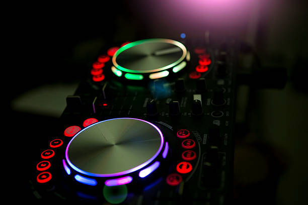 DJ console music party in nightclub with colored disco lights.