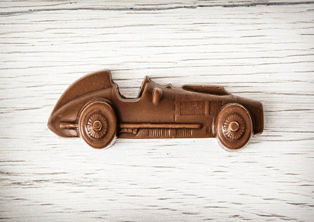 istock Little chocolate car figure on wooden background 513371000
