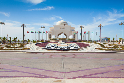 Huge Plaza with flags and Emblem of the United Arab Emirates and entrance arch to the presidential palace