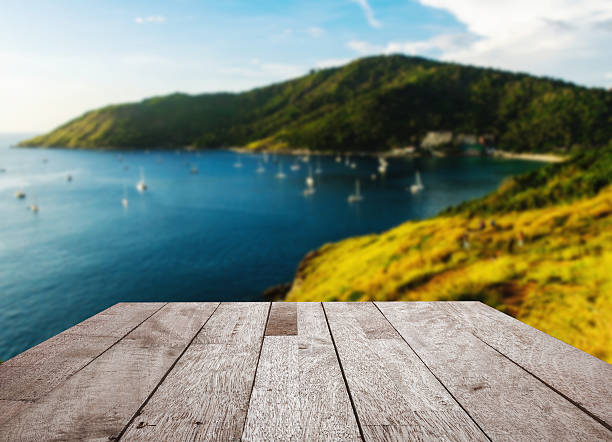 istock Wood floor top on blurred blue sea with island 513375742