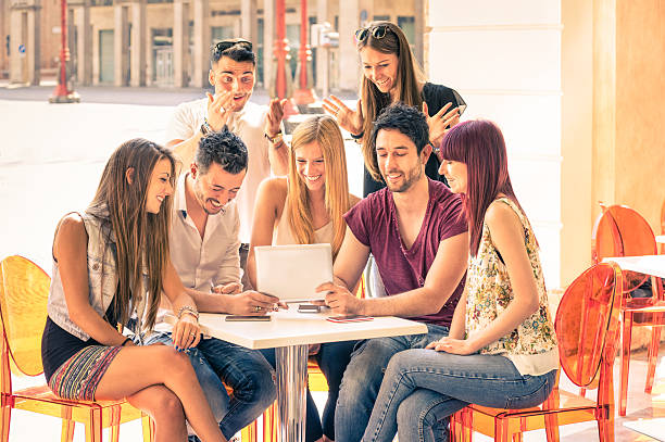 istock Friends group sitting at restaurant bar having fun with tablet 513377264