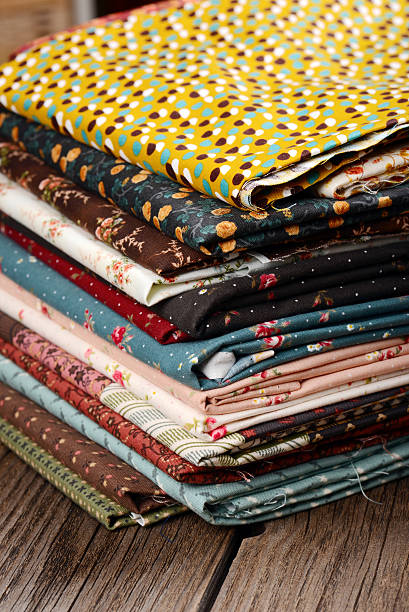 istock heap of cloth fabrics on wooden table 513379191