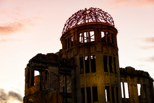 Hiroshima A-Bomb Dome, Genbaku Domu, against evening red sky. A-Bomb Dome in Hiroshima,the first atomic bomb to be used in war detonated almost directly above the dome on August 6, 1945.