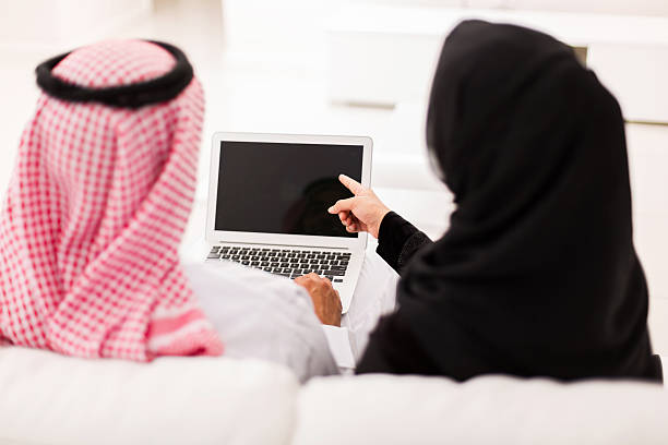 coppia musulmana che indica al computer portatile schermo - ghoutra foto e immagini stock