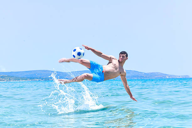 Salvador, Bahia, Brazil - February 14, 2019: Young people are seen having fun and playing beach soccer in the late afternoon in the city of Salvador, Bahia.