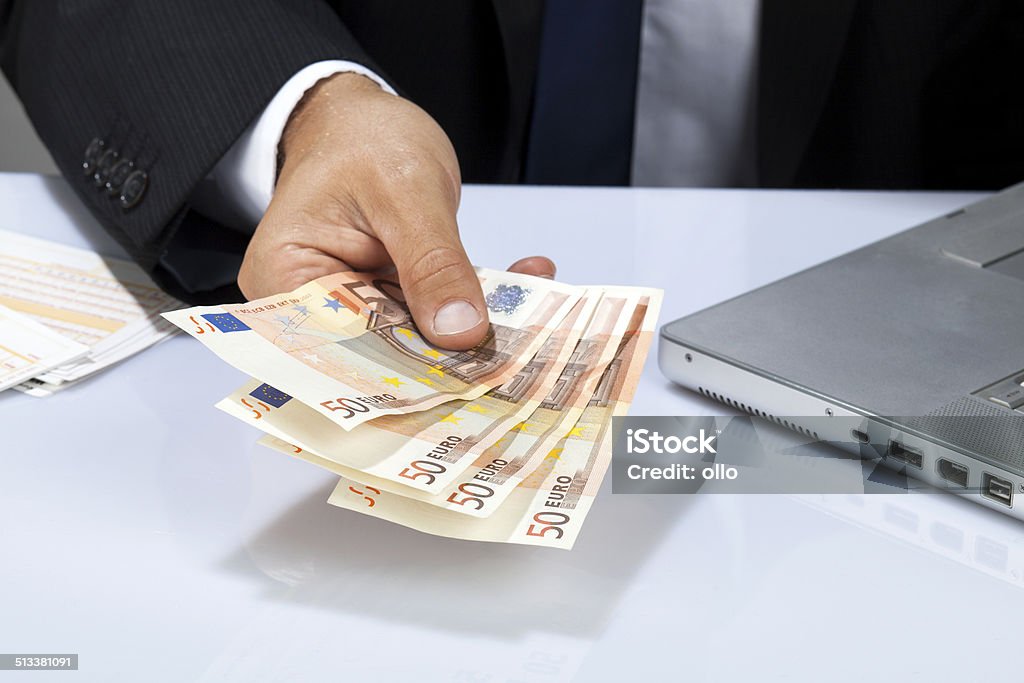 Offering money An unrecognisable businessman or office worker offers fifty euro banknotes. Adult Stock Photo