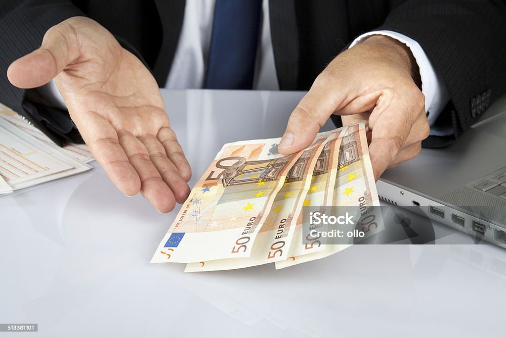 Offering money An unrecognisable businessman or office worker offers fifty euro banknotes. Adult Stock Photo