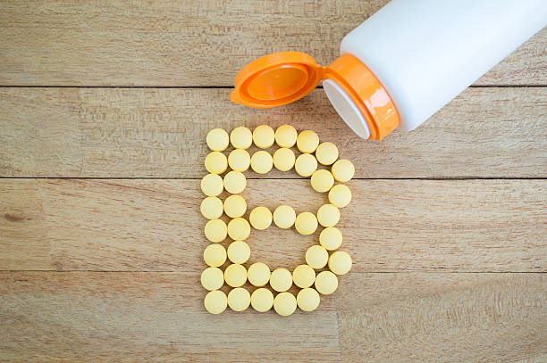 istock Yellow pills forming shape to B alphabet on wood background 513381334