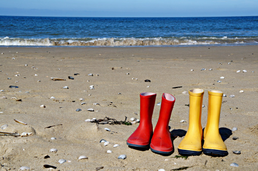 Red and yellow rain boots on the beach, Texel