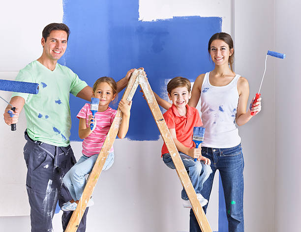 Family painting wall blue together