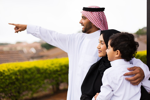 Musulmana familia señalando en su casa photo