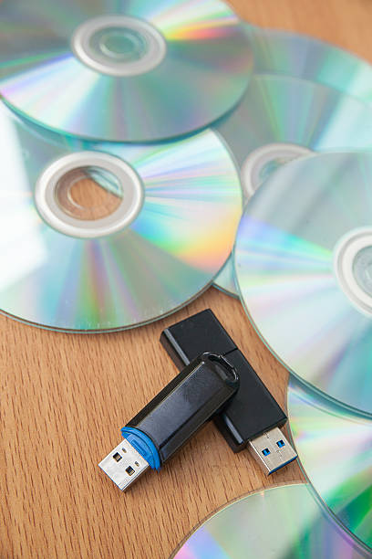 usb flash unidades de e empilhados cd isolado sobre fundo de madeira. - usb flash drive fotos imagens e fotografias de stock