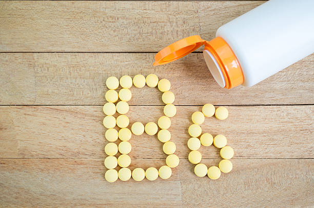 istock Yellow pills forming shape to B6 alphabet on wood background 513384512
