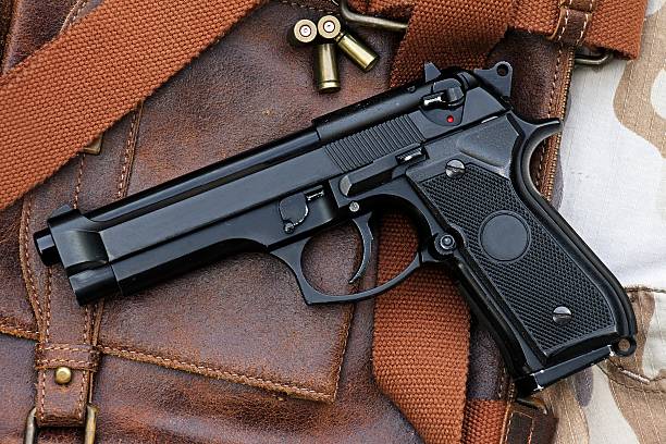 istock handgun lying over a Leather handbag. 513384567