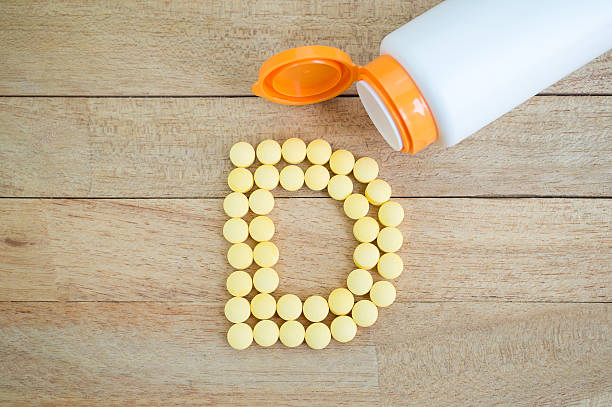 istock Yellow pills forming shape to D alphabet on wood background 513384794