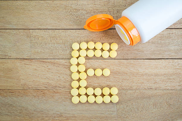 istock Yellow pills forming shape to E alphabet on wood background 513384962