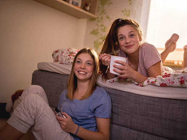dziewczyna przyjaciółmi ciesząc się w telewizor pokaż w sypialni - friends television show zdjęcia i obrazy z banku zdjęć