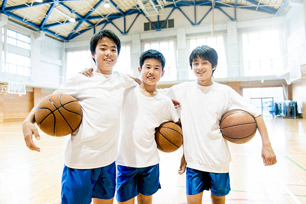 Japanese Basketball Team Japanese Junior High School friends playing basketball in the School GYM. child japanese culture japan asian ethnicity stock pictures, royalty-free photos & images