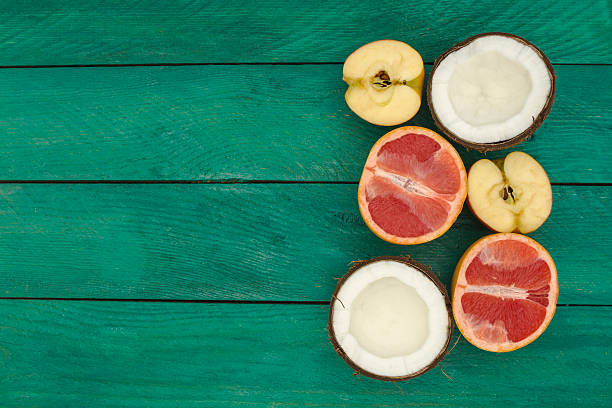 istock sliced fruit - grapefruit, coconut, apple, on a wooden background. 513388566