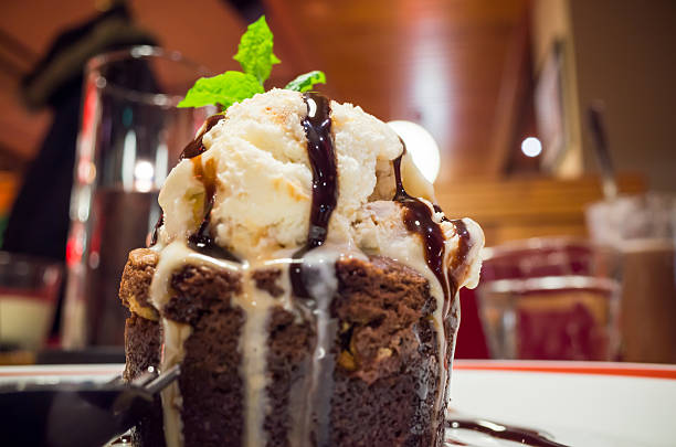 Molten chocolate cake with ice cream ball Molten chocolate cake with ice cream and mint leaf. Some other names used are chocolate fondant, chocolate moelleux or chocolate lava cake ice pie photography stock pictures, royalty-free photos & images