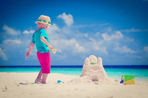 istock little boy playing with sand on tropical beach 513392307