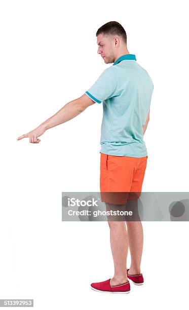 Back View Of Pointing Young Men In Tshirt And Shorts Stock Photo - Download Image Now