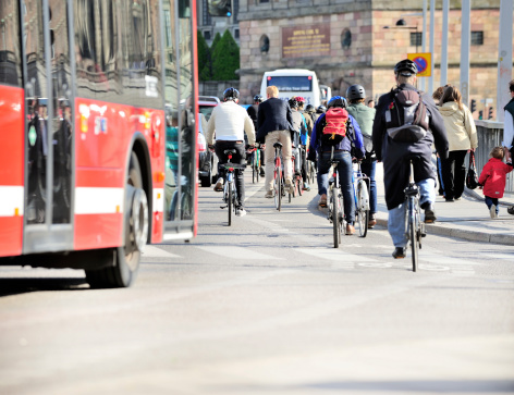 Crowded bike lane. Motion blur, bus/car in background. The building in the background is the Stockholm Castle where the Swedish king lives.