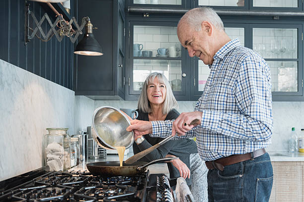 istock Senior man holding bowl making dinner, his wife is watching 513394514